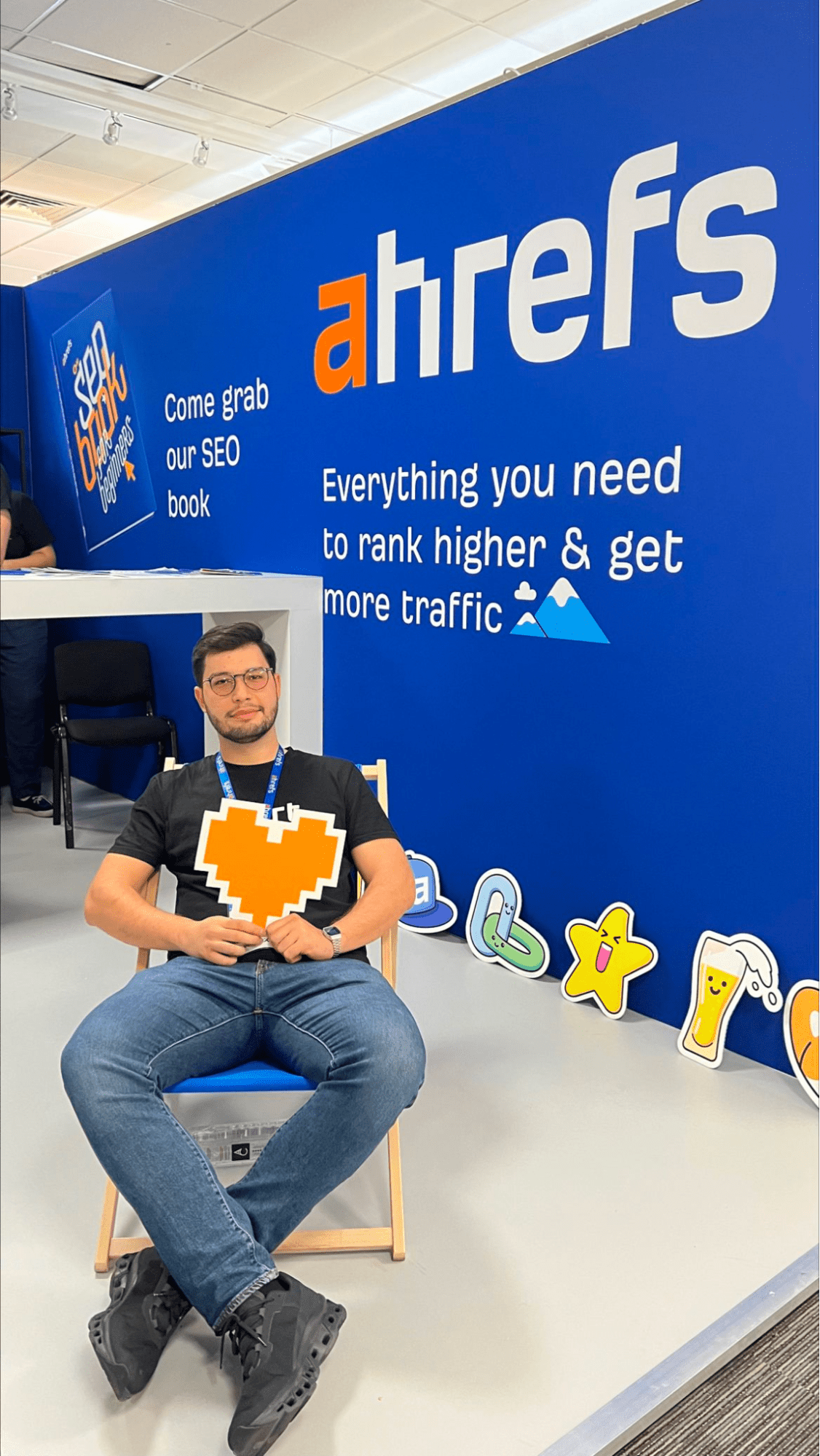 Dear BrightonSEO, You've Come a Long Way, Baby | Andrei Țiț relaxing in a chair at Ahrefs' exhibitor stand